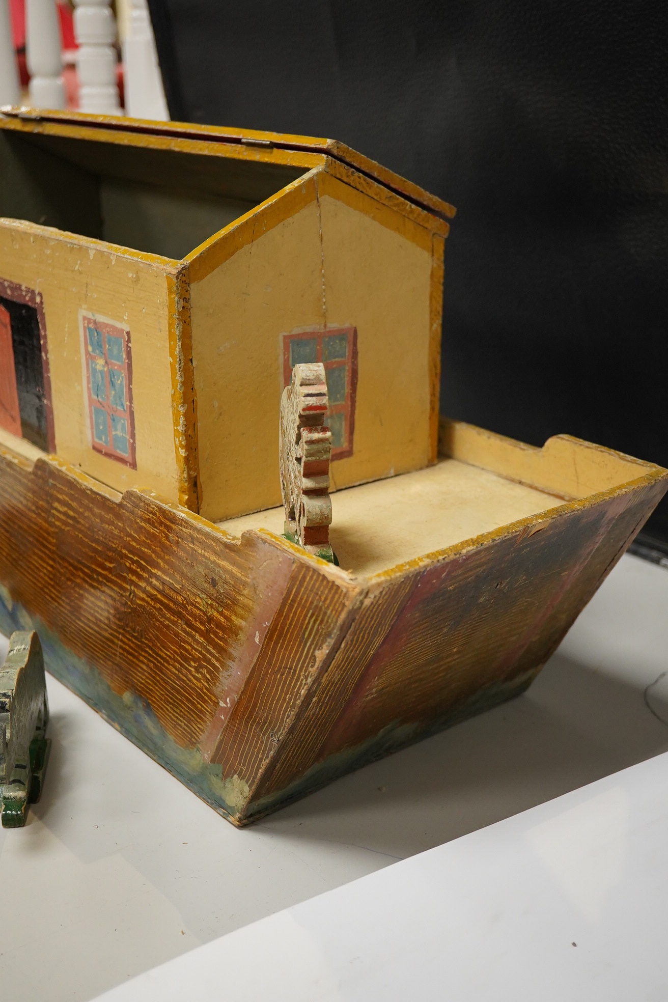 An early 20th century painted pine Noah's Ark and semi-flat animal figures, the hull 68.5cm long. Condition fair, general wear and scuffing to the paintwork.